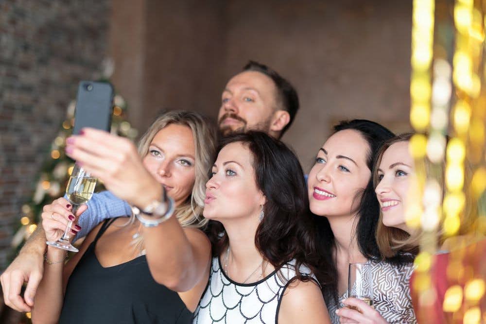 A group of people taking pictures at a party or wedding, friends